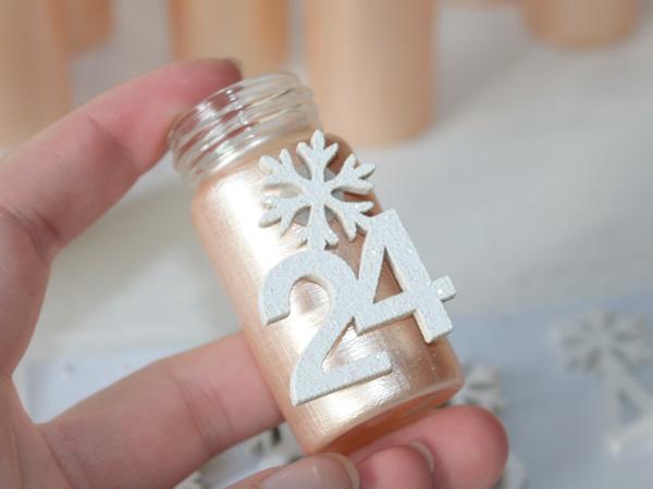 Die Nummern und Dekoteile befestigen und der Adventskalender ist fertig